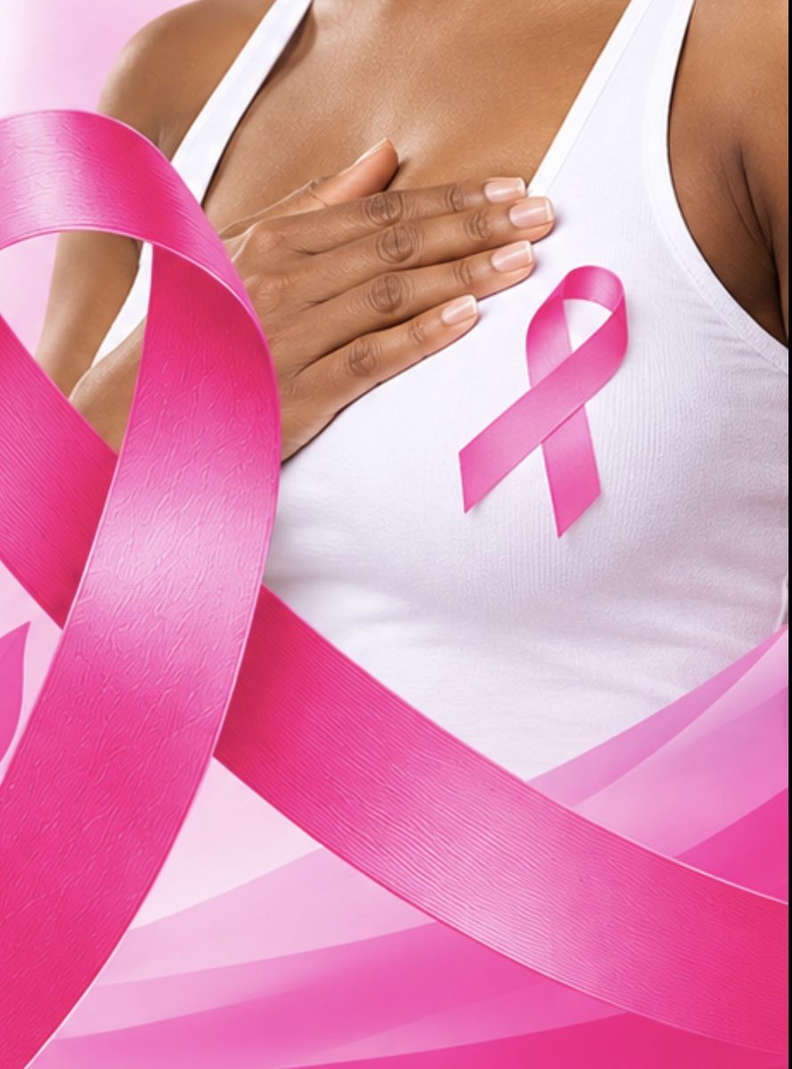 Woman with hand on her chest wearing a pink breast cancer awareness ribbon